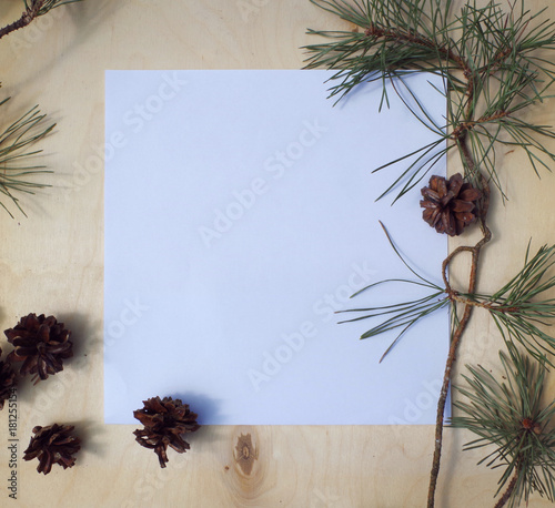 Mockup concept with pine branches and cones. The blank white page on the rustic background with natural decorations.