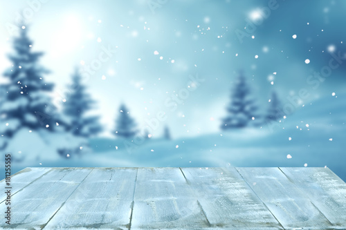 Merry christmas and happy new year greeting background with table .Winter landscape with snow and christmas trees © Lilya