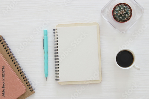 top view of open notebook with blank pages next to cup of coffee on wooden table. ready for adding text or mockup © tomertu