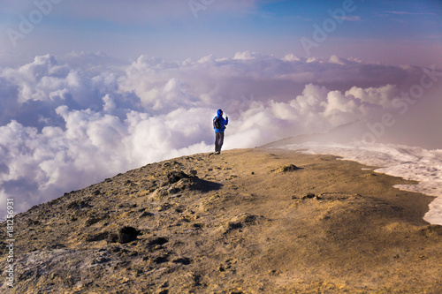 Escursionista solitario al tramonto con  colori del cielo e nuvole suggestivi sul vulcano Etna- Sicilia photo