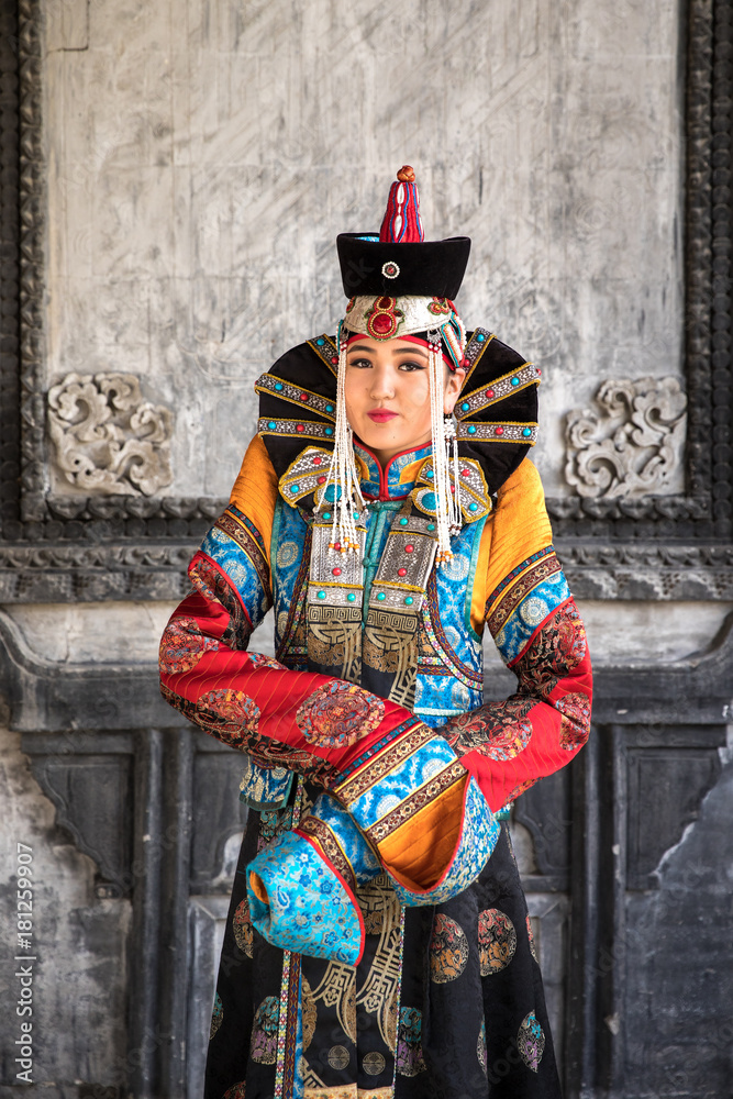 Young Mongolian woman in a traditional 13th century costume in a temple ...