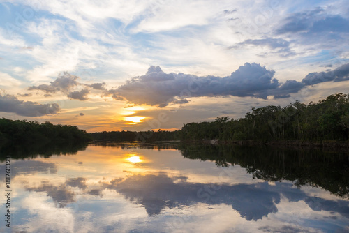 Reflections of sky and trees on the waters of the Sipapo river, in the amazon jungle.
