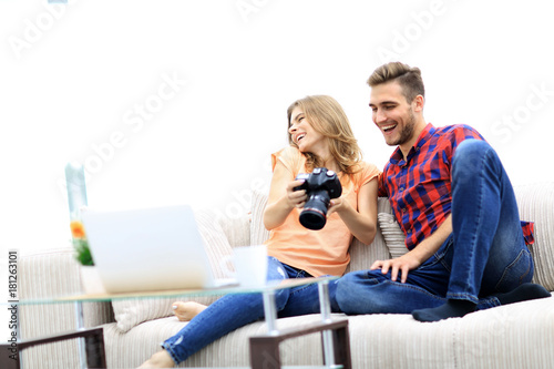 young couple with a photo camera makes viewing photos