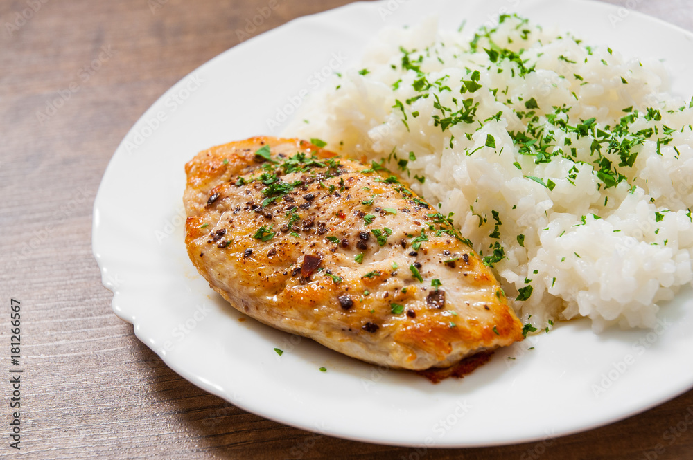 fried chicken breast with rice on a wooden background.
