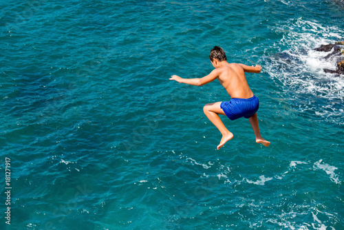 Young boy jumping in the sea