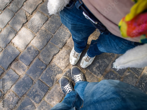 The feet of two tourists on the paving stones - a top view.