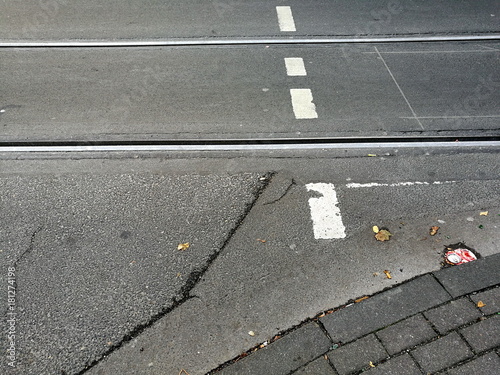 Ausgebesserte graue alte Straße mit Fußgängerüberweg und Straßenbahnschienen im Stadtteil Klettenberg in Köln am Rhein in Nordrhein-Westfalen