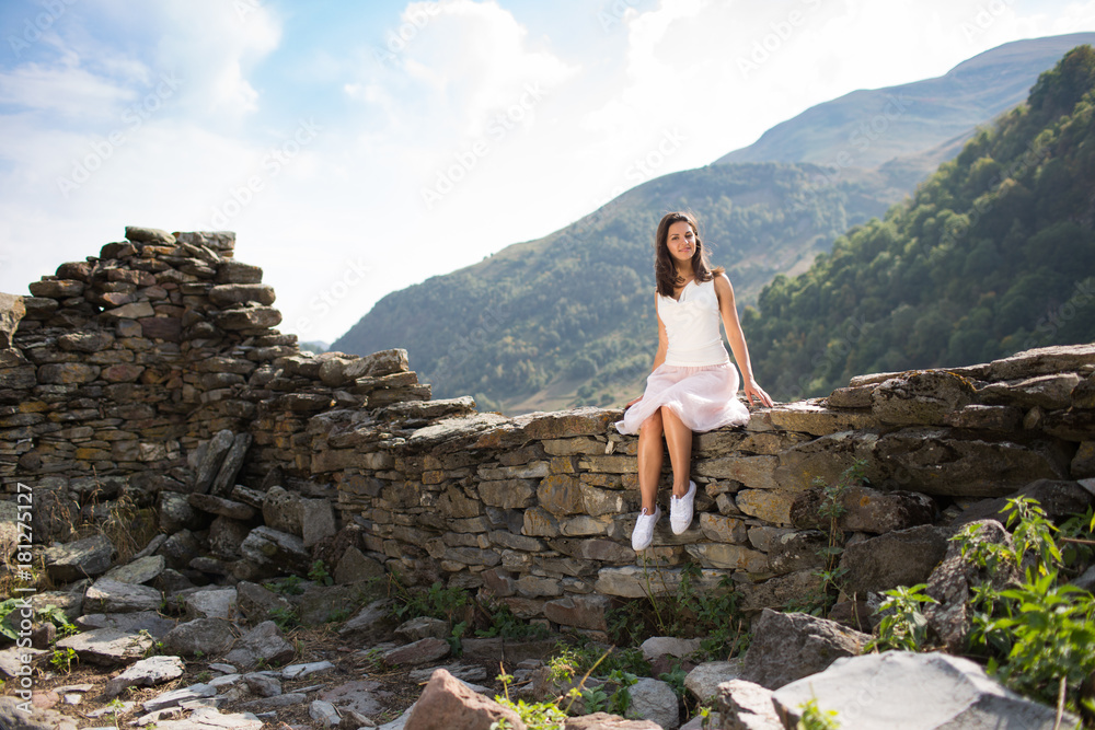 Naklejka premium Young woman near a stone wall