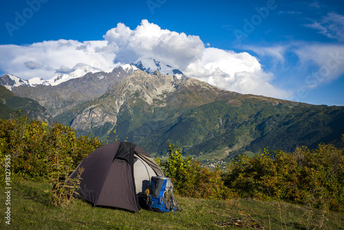 The tent stands on the background of high mountains. Around the wonderful landscape. Evening. Sunset. Tourism in the Caucasian Mountains in Georgia.