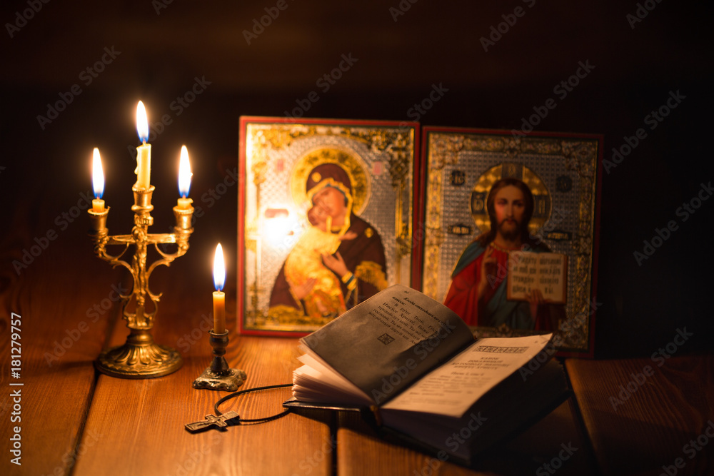 Naklejka premium burning candle in a dark room, orthodox