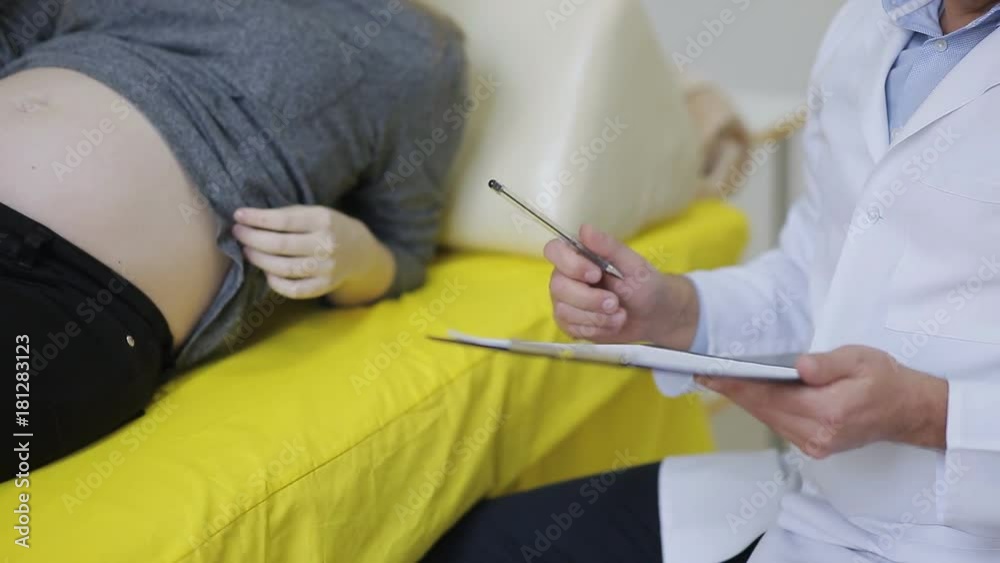 a doctor examines a pregnant woman and writes to the medical appointment card for treatment a doctor examines a pregnant woman and writes to the medical appointment card for treatment