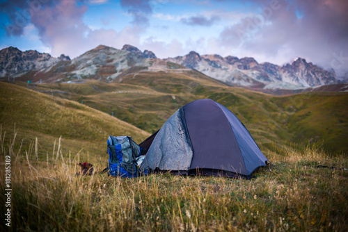 The tent stands on the background of high mountains. Around the wonderful landscape. Morning. Sunrise. Tourism in the Caucasian Mountains in Georgia.