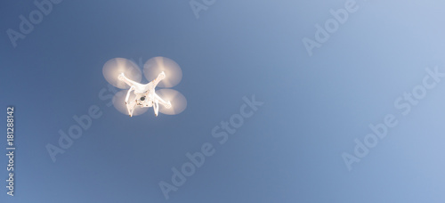 Fotografie, Tablou White UAV Quadcopter Drone in Flight Blue Sky