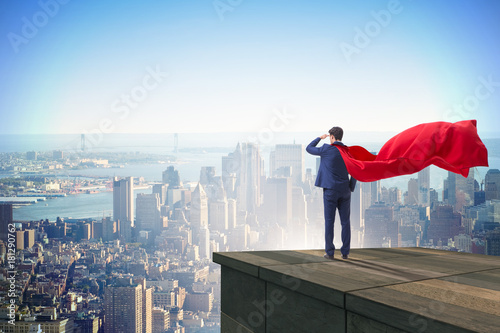 Super hero businessman on top of building ready for challenge
