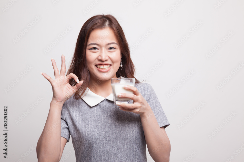 Healthy Asian woman drinking a glass of milk show OK sign. Healthy Asian woman drinking a glass of milk show OK sign.