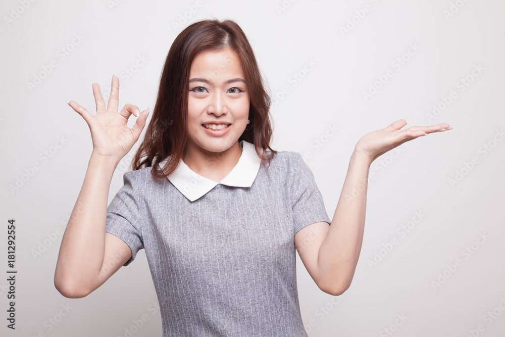 Beautiful young Asian woman show palm hand and OK sign. Beautiful young Asian woman show palm hand and OK sign.