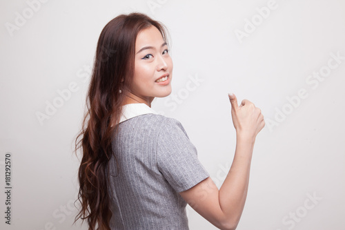 Young Asian woman turn back thumbs up.