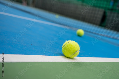 Yellow tennis ball on blue and green hard court surface  © ivanaculafic
