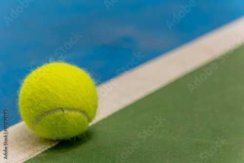 Yellow tennis ball on blue and green hard court surface  © ivanaculafic