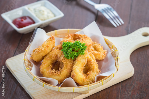 Fried calamari rings in wicker basket and sauce