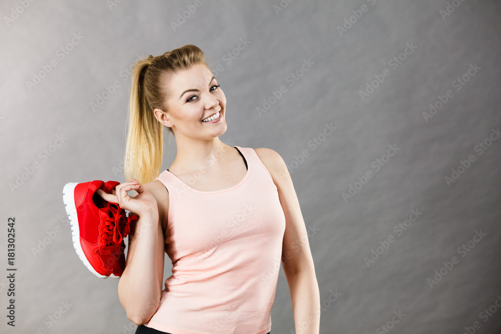 Happy woman presenting sportswear trainers shoes Happy woman presenting sportswear trainers shoes