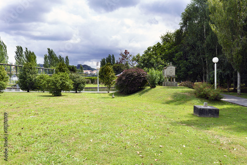 Garden with well-kept lawn and trees with cloudy sky. Park of the brothers Naveira in Betanzos, Galicia, Spain photo