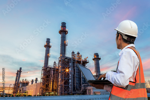  Engineering is use notebook check and  standing in front of oil refinery building structure in heavy petrochemical industry