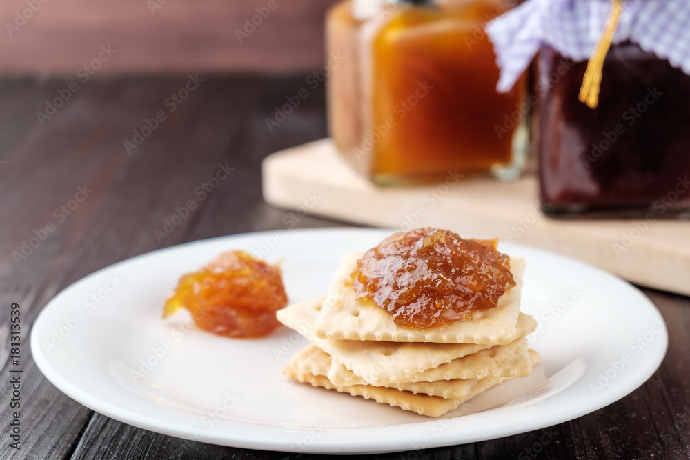Crackers with orange jam on wooden background Crackers with orange jam on wooden background