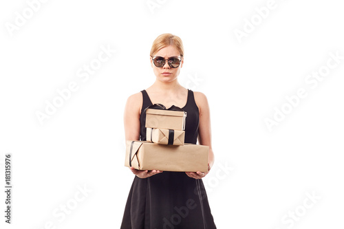 Portrait of elegant blonde woman in black dress and sunglasses holding gift boxes