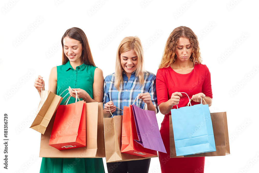 Portrait of three young girlfriends holding bunches of multi-colored shopping bags Portrait of three young girlfriends holding bunches of multi-colored shopping bags
