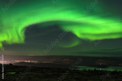 Aurora in the night sky,hills, and tundra. © Moroshka