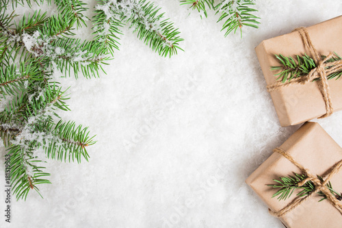 Snowy fir branches and gifts on snow. Christmas and New Year background with copy space.