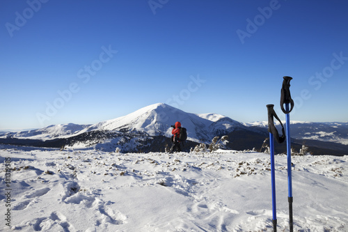 Photographer make photo in snow mountains at nice sun winter day and ski poles