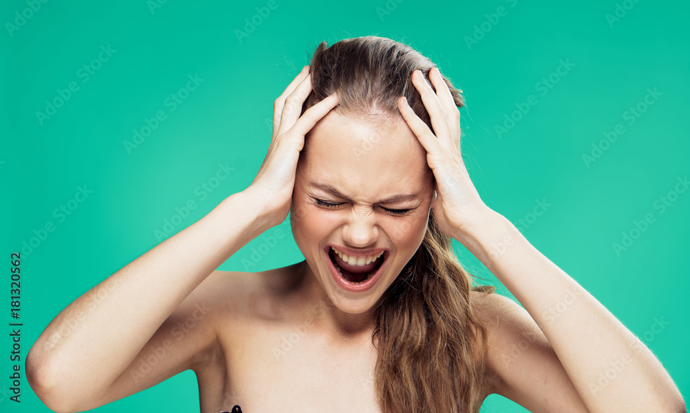 Beautiful young woman on a green background, scream, emotion, portrait