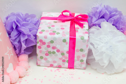 Closeup image of present and tissue pompoms for kid's birthday party