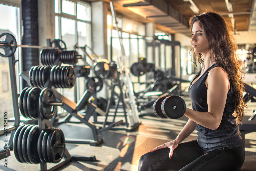 Sporty young woman lifting weight in gym. Sporty young woman lifting weight in gym.