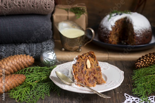 English Christmas pie with vanilla sauce in festive decoration. Rustic style. photo