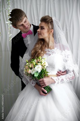 Beautiful young bride and groom posing at studio