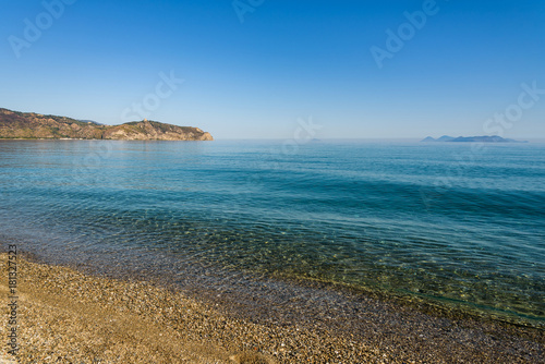 Crystal clear sea water, Bazia beach, Falcone, Sicily. In the background the sanctuary of Tindari