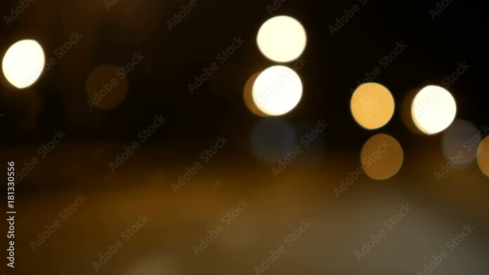 Driving a car through night road, highway. Defocused lights Los Angeles street abstract . City blur background. Moving bokeh circles of night traffic. Driving a car through night road, highway. Defocused lights Los Angeles street abstract . City blur background. Moving bokeh circles of night traffic.