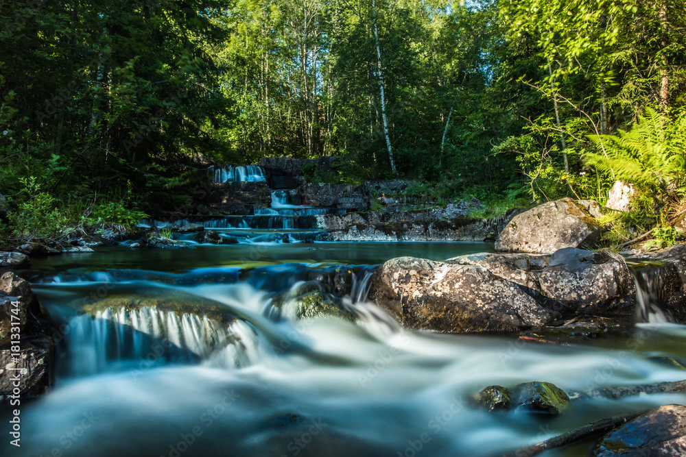 Fototapeta premium A beautiful river with small watefalls and bridge