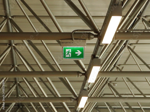 Green Exit Sign under Grid Roof with Lamps