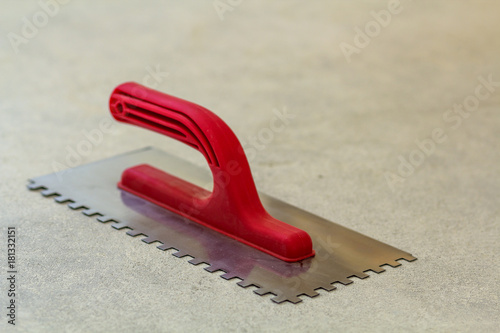 Construction notched trowel is a tool for tiles installation work