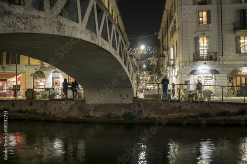 Milan, Italy: bridge across the Naviglio Grande canal waterway at evening. This district is famous for its restaurants, cafes, pubs and nightlife.