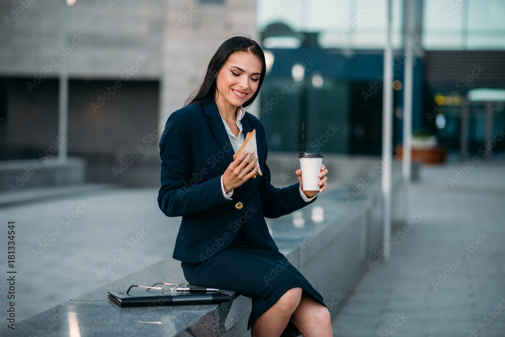 Happy business woman with sandwich and coffee Happy business woman with sandwich and coffee