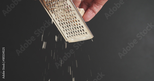 Quadro em tela closeup of grating aged parmesan over dark background