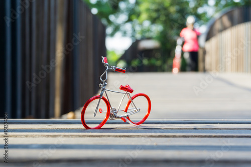 Toy red bicycle on wood floor, in the park.
