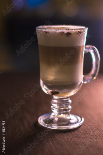 Coffee in a glass cup in a cafe with a blurred background.