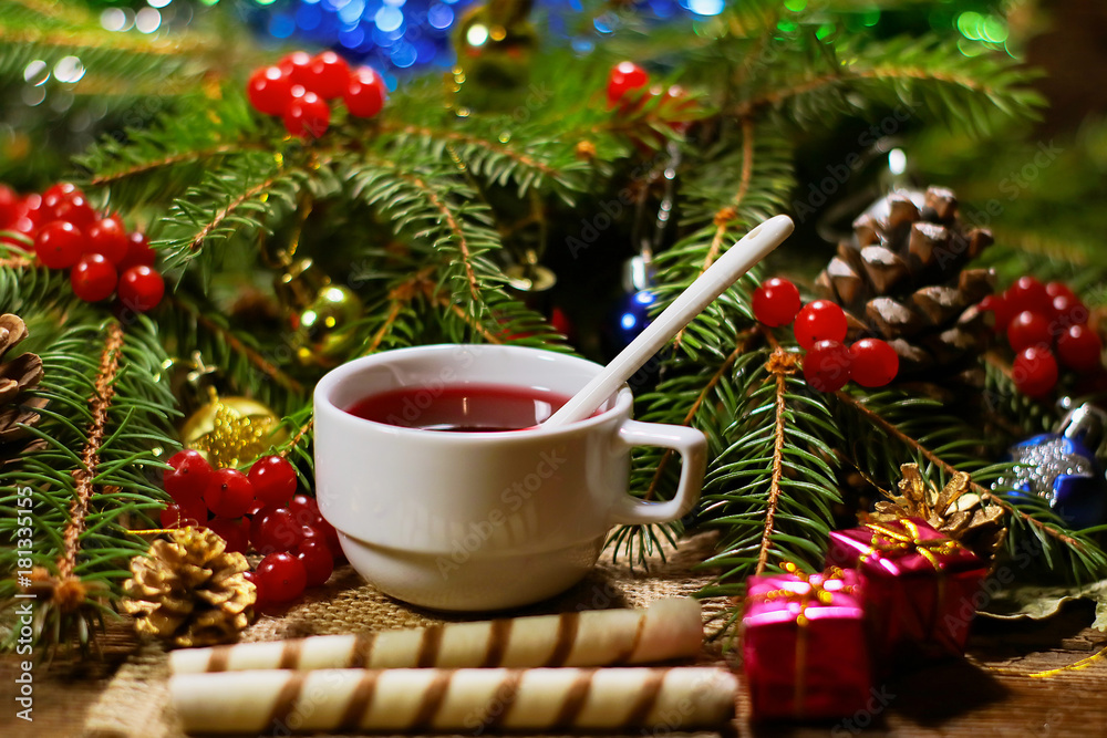 rowan tea in a white cup and cookies - tubes. fir branches with rowan. New Year's and Christmas decorations.