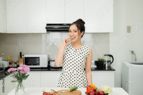 Asian wman preparing healthy meal in her rustic eco kitchen